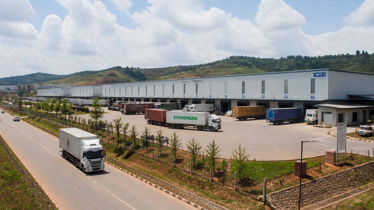 Warehouses with loading bays and articulated lorries at an industrial park outside Kampala