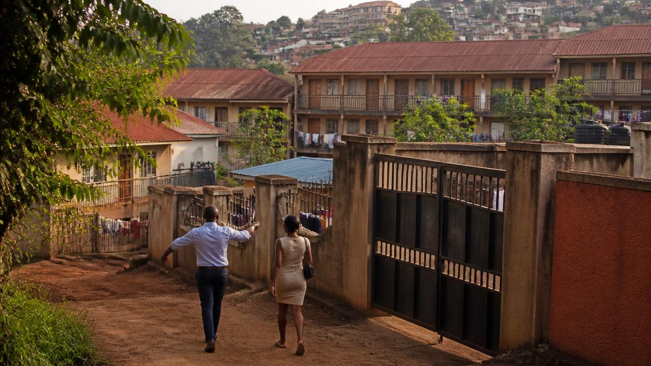 Rental apartment blocks and gated compounds in a Kampala suburb, with a broker walking a prospective tenant towards a gate